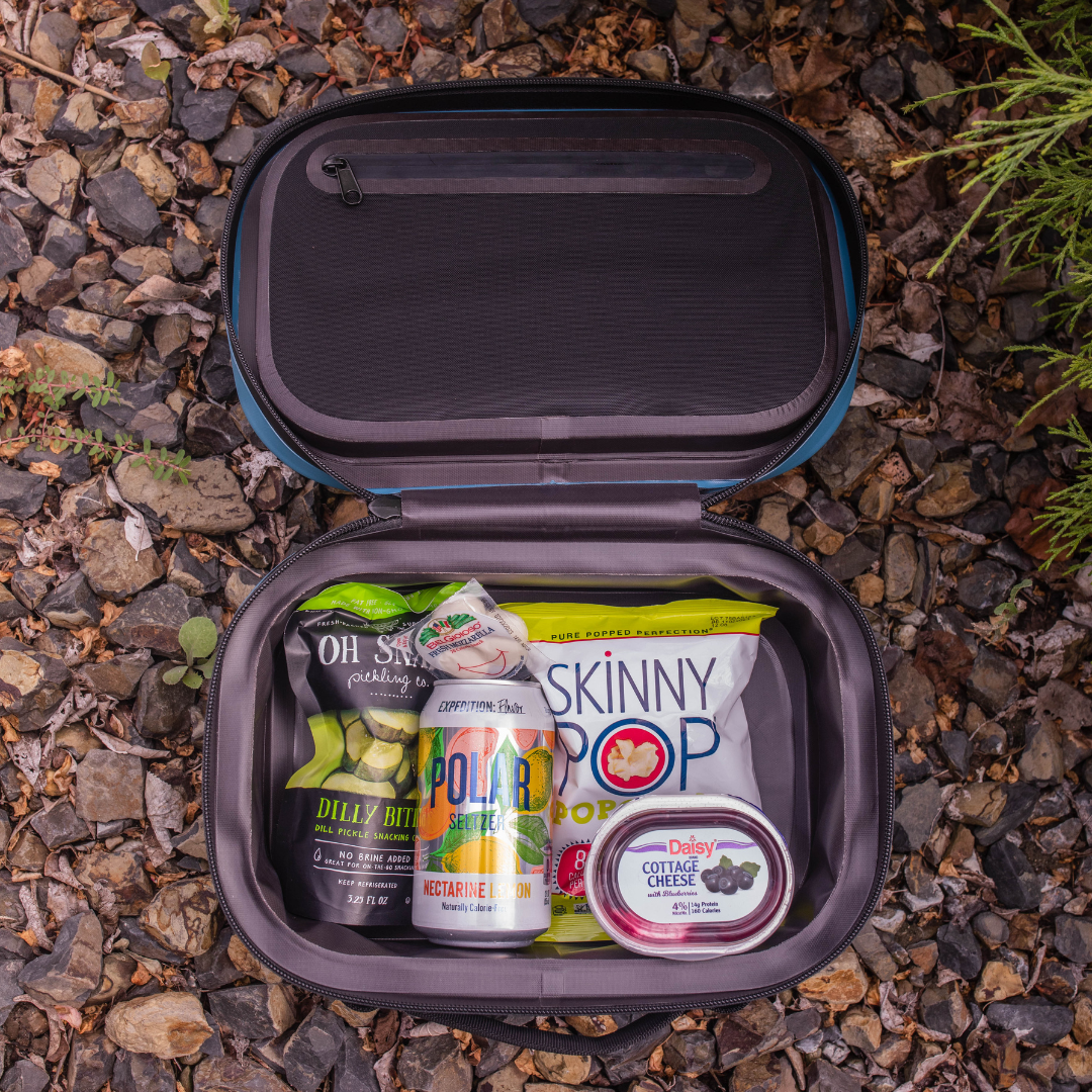 BACKCOUNTRY CLASS™ COOLER LUNCH BAG in black and blue ballistic nylon, open with snacks and drinks inside