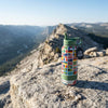 COLDEST 24oz Limitless water bottle in green with a colorful international flag pattern and leak-proof lid