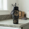 Coldest Mini 6.7oz Insulated Water Bottle in black with gold celestial moon and stars design, straw lid and side handle